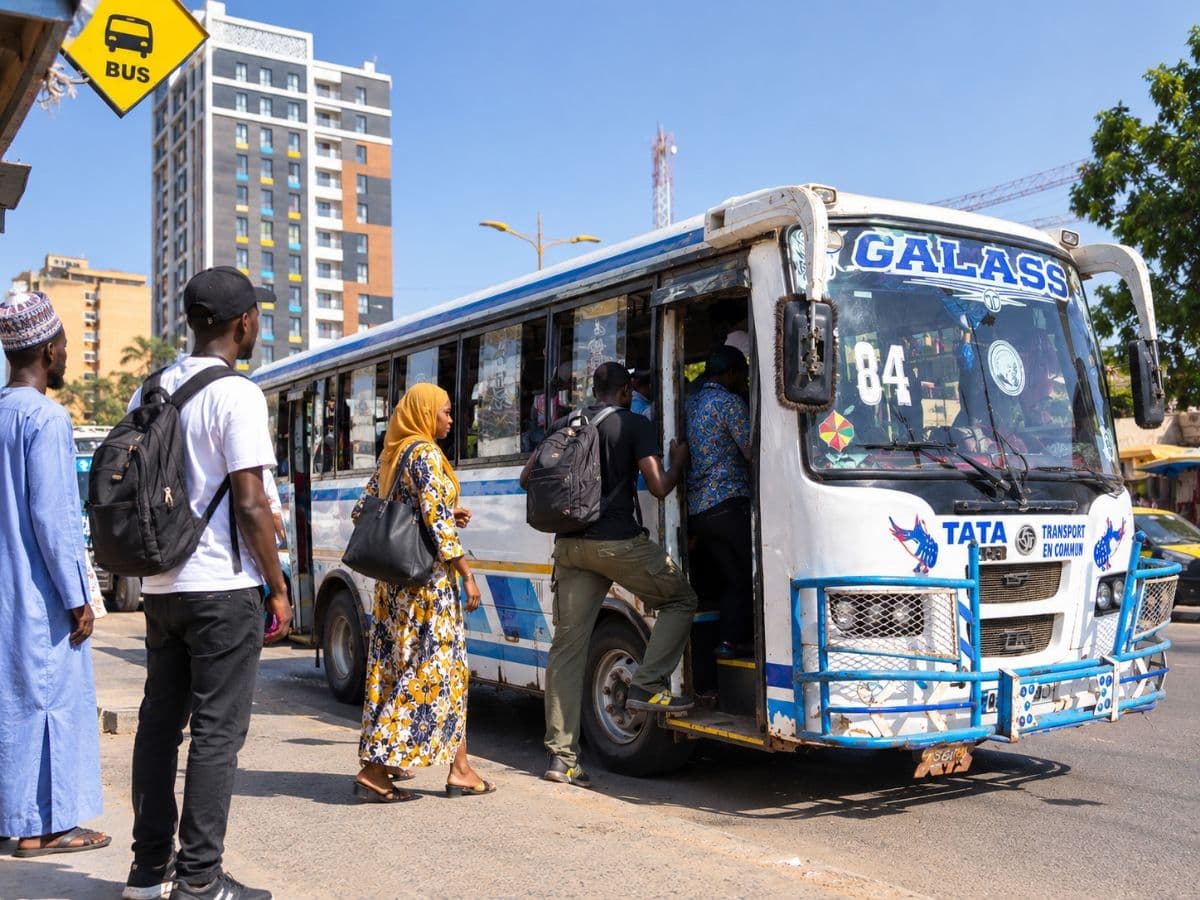 Des usagers montent dans un bus Tata à un arrêt de Dakar.